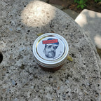 Chili Flores jar with a lid featuring a face design on a textured stone surface